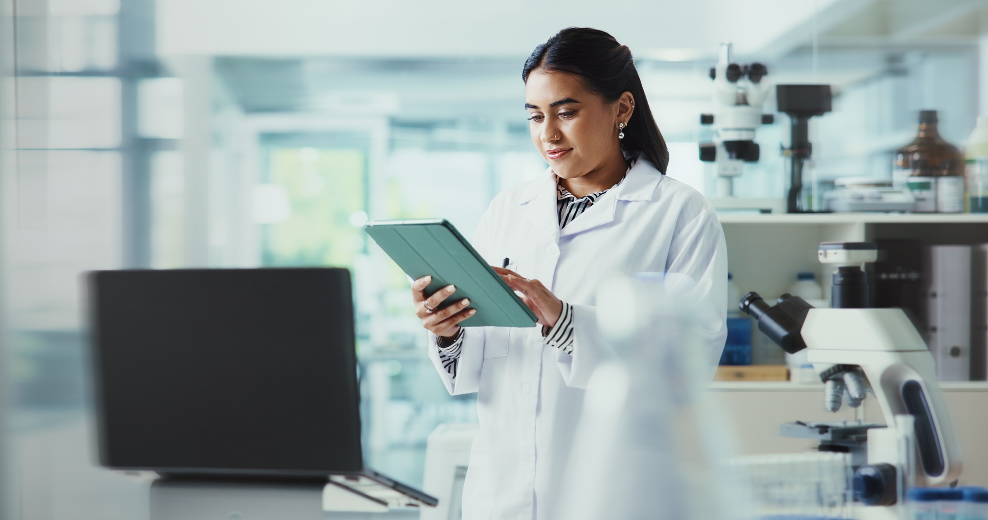 Tablet, woman and scientist in laboratory for research on healthcare innovation with biomedical eng